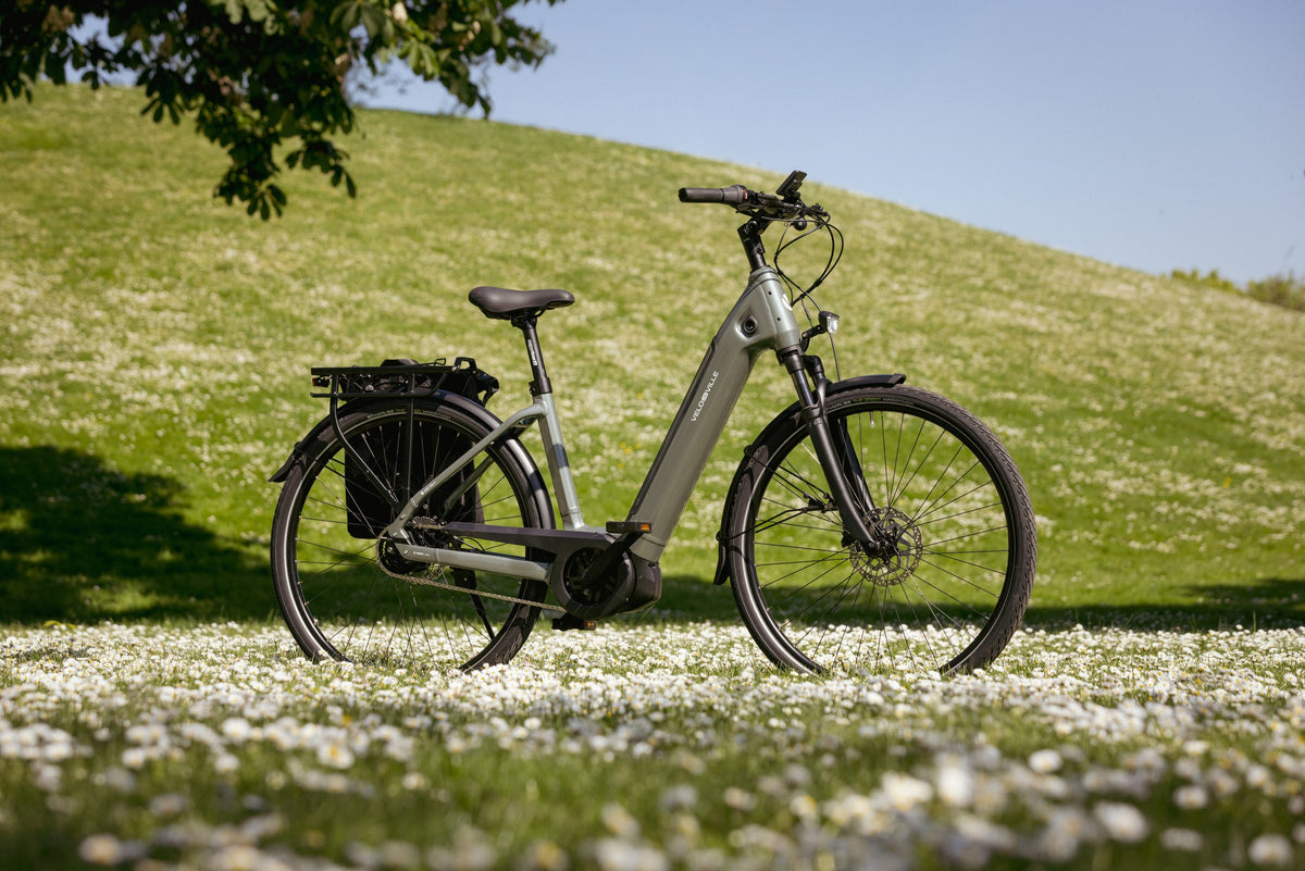 Grå elcykel fra Velo de Ville på en græsbakke