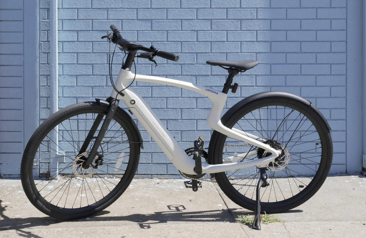 Urtopia Carbon 1 Pro foran en blå murstensvæg