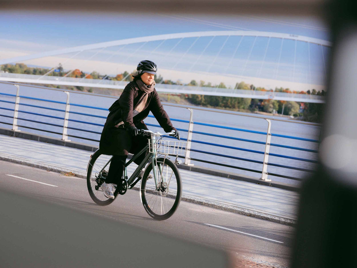 Cyklist på en Pelago Lovisa elcykel ved en bro